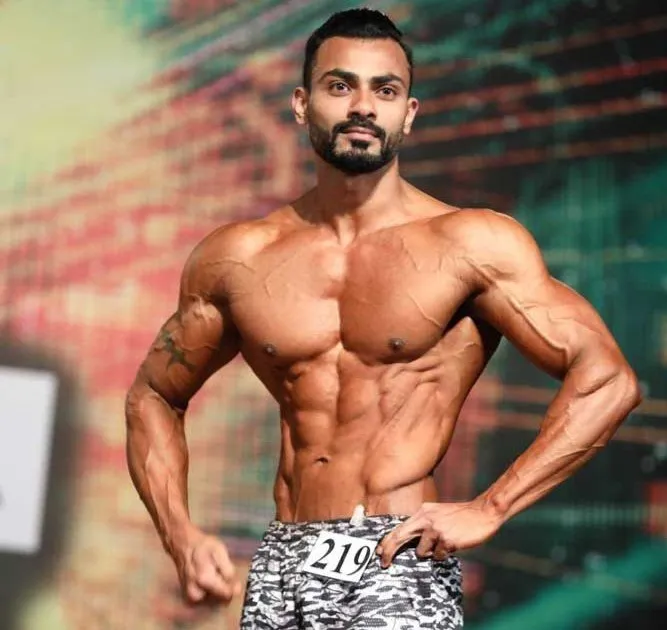Mohammed Akram, founder of Muscularity Fitness, on a bodybuilding stage